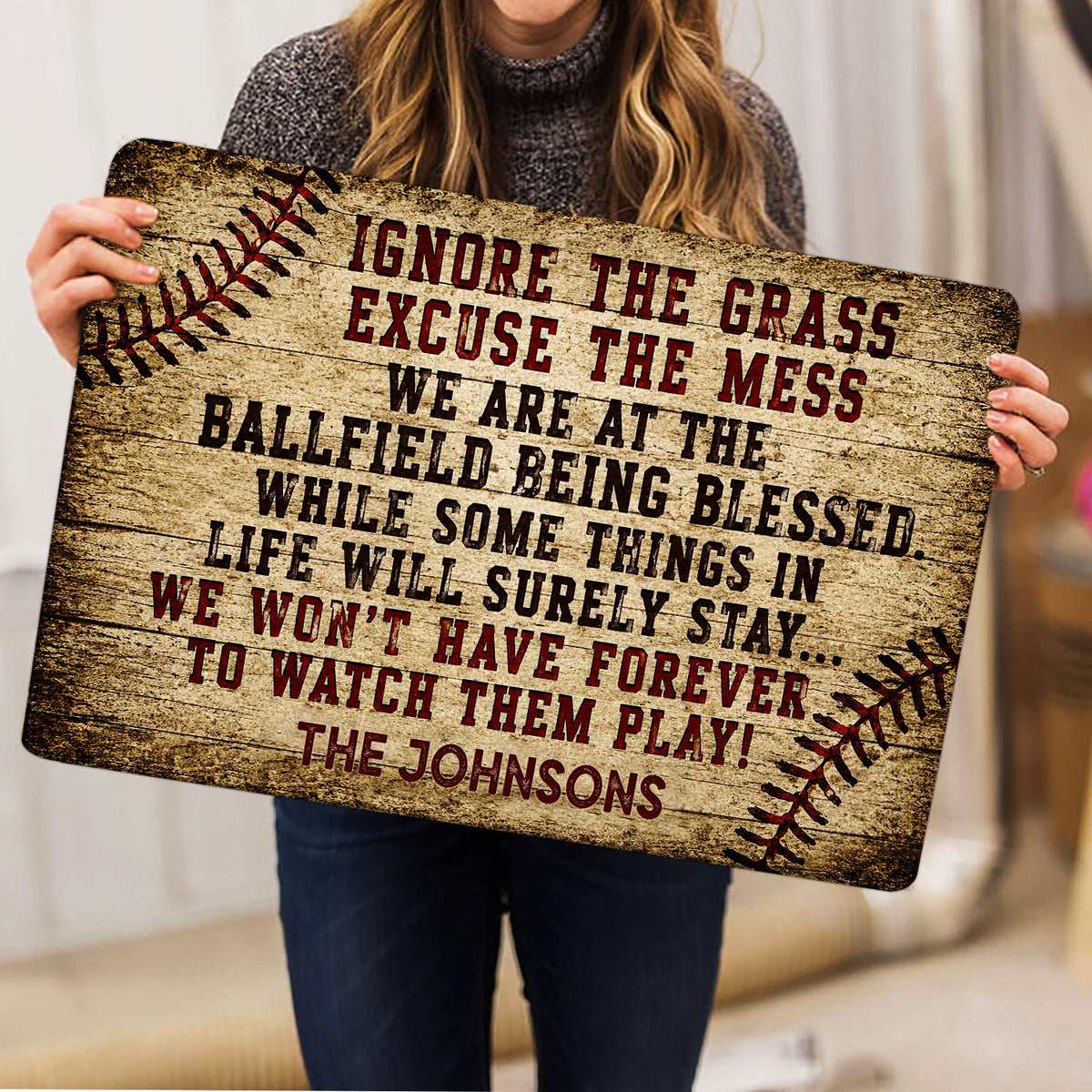 Baseball doormat held indoors, showing rustic ballfield artwork and bold decorative lettering
