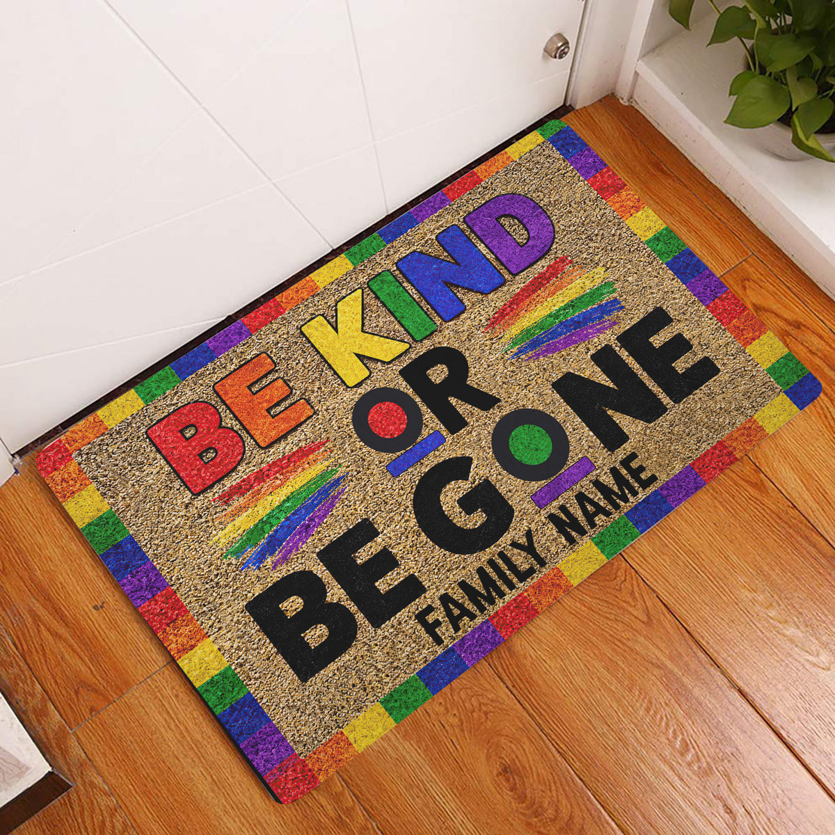 LGBT rainbow Be Kind doormat displayed inside a home entryway on a wood floor