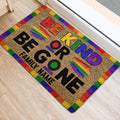 Colorful Be Kind LGBT entryway rug positioned beside a doorway on light wood flooring