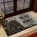 Rustic bear doormat displayed near a glass door with woodland foliage and honey-themed artwork
