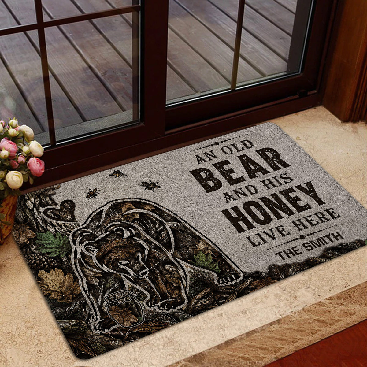 Rustic bear doormat displayed near a glass door with woodland foliage and honey-themed artwork