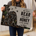 Bear doormat held indoors, showing the detailed forest scene, bees, honey jar, and decorative lettering