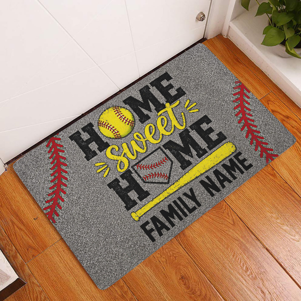 Softball home-themed doormat displayed in an entryway with a yellow bat, softball, glove, and red stitching