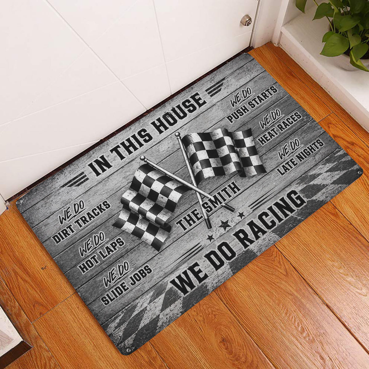 Checkered flag racing doormat displayed at a home entrance on a warm wood floor