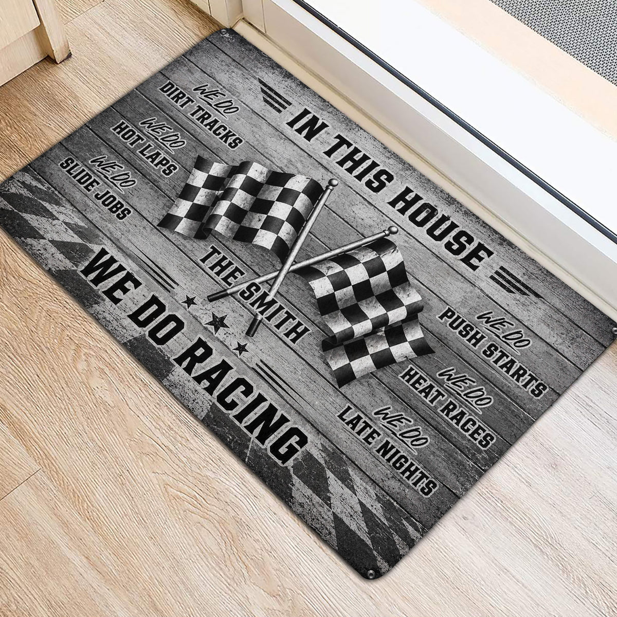Racing entryway mat positioned beside a doorway with crossed flags and bold black and gray artwork