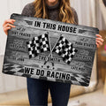 Racing doormat held indoors, showing crossed checkered flags, bold typography, and a black and gray design