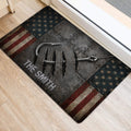 Rugged fishing-themed door mat with hook artwork and star-and-stripe border positioned at an entry door