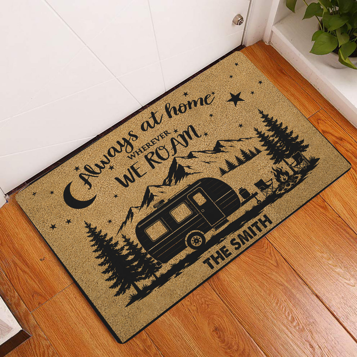 Camping entryway doormat displayed by a front door on hardwood flooring with an RV and mountain scene
