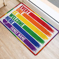 Colorful LGBT pride welcome mat positioned at an interior doorway on light wood flooring