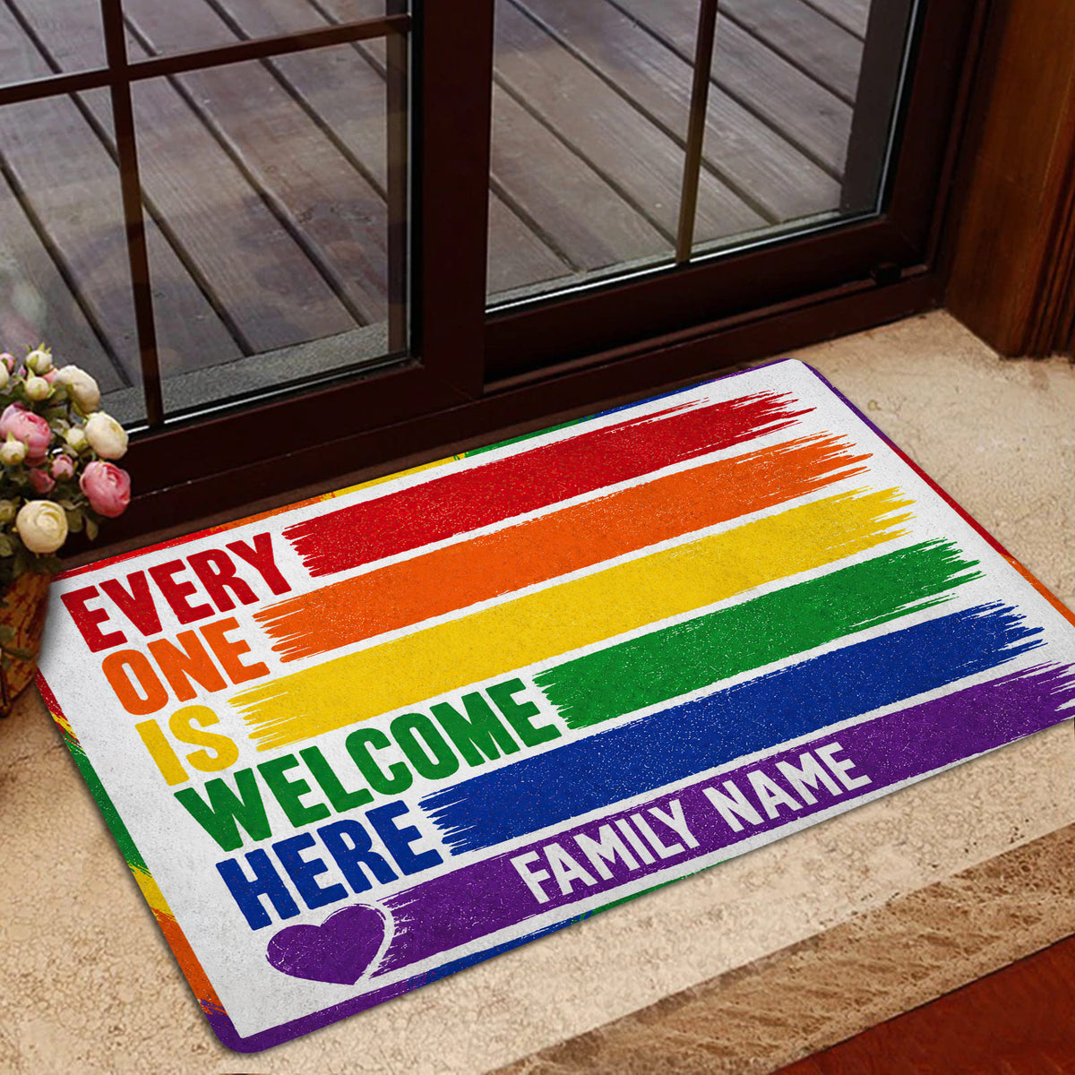 Rainbow pride entryway mat styled near a glass door with colorful stripes and an inclusive welcome design