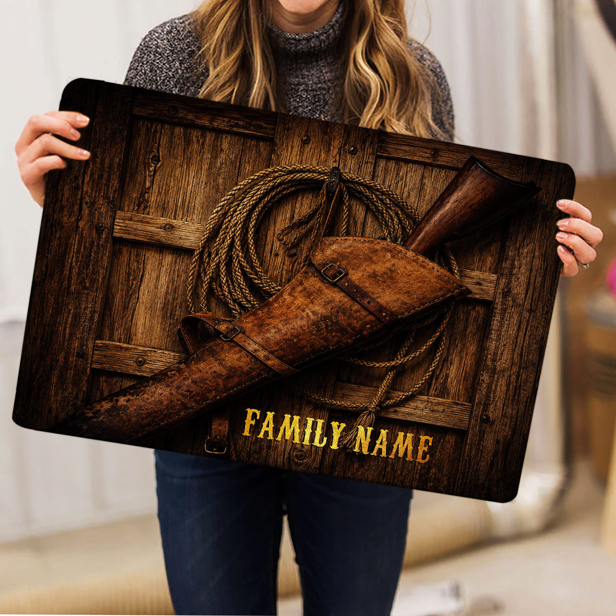 Cowboy doormat held indoors, showing rustic wood artwork, lasso, leather holster and rifle
