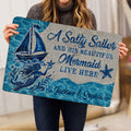 Mermaid doormat held indoors, displaying a blue ocean scene with sailboat and starfish