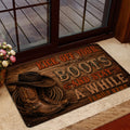 Cowboy entryway mat shown by a glass door with western boots, hat and rope design