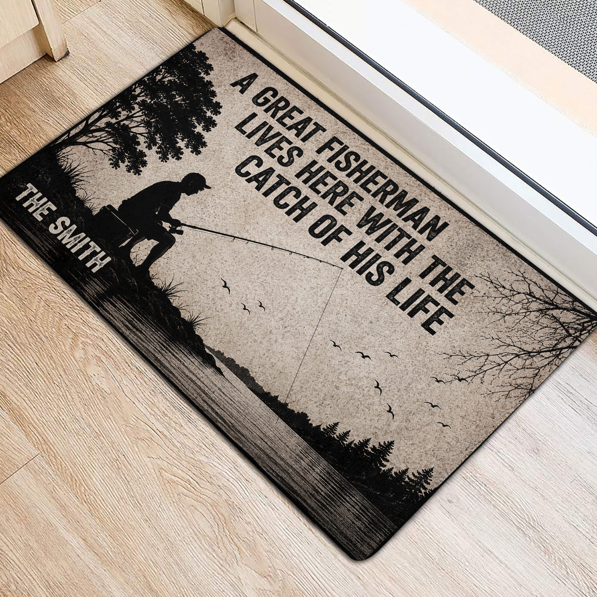 Fishing door mat positioned near a doorway, featuring an angler, fishing rod, lake and woodland silhouettes