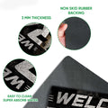 Racing doormat feature view showing printed top, rubber backing, thin profile, and traction-focused construction