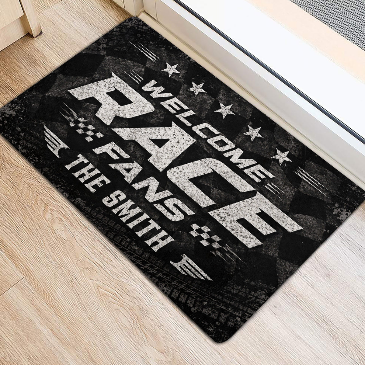 Black and white racing door mat positioned beside an entry door on a light wood floor