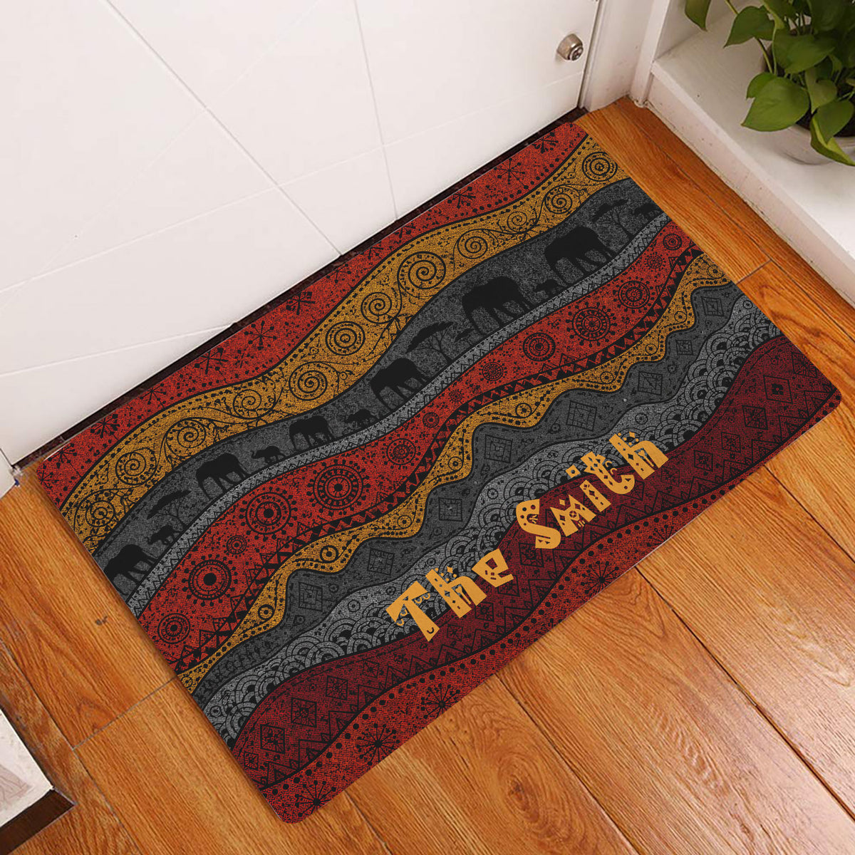 African elephant entryway rug displayed by a white door on a wood floor with bold patterned bands