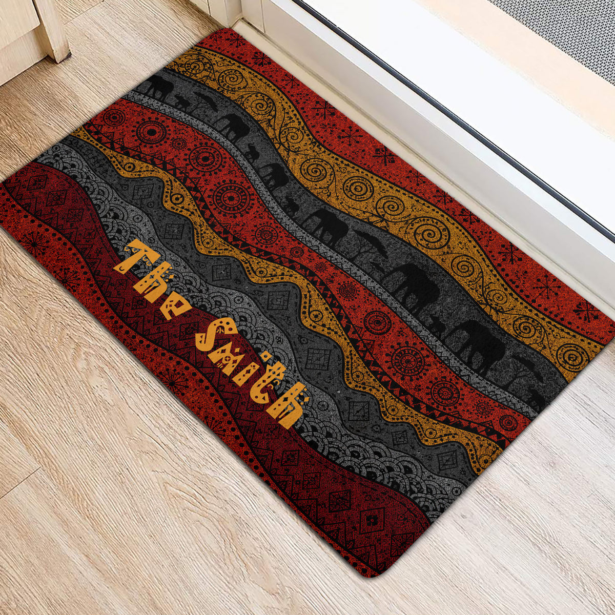 African-inspired elephant door mat positioned at an entryway with red, gold, and charcoal artwork