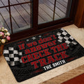 Racing entryway mat displayed beside a glass door with checkered flag graphics and bold red lettering