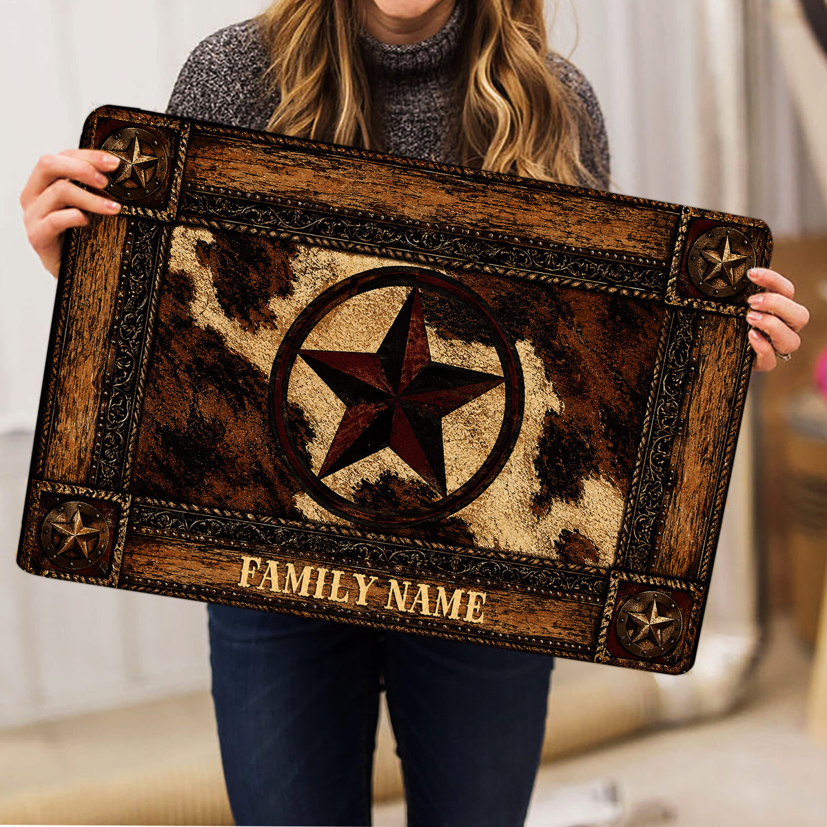 Person holding a rustic cowboy doormat featuring a central star and ornate Western border