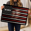Person holding a baseball-themed doormat featuring rows of red and white bats