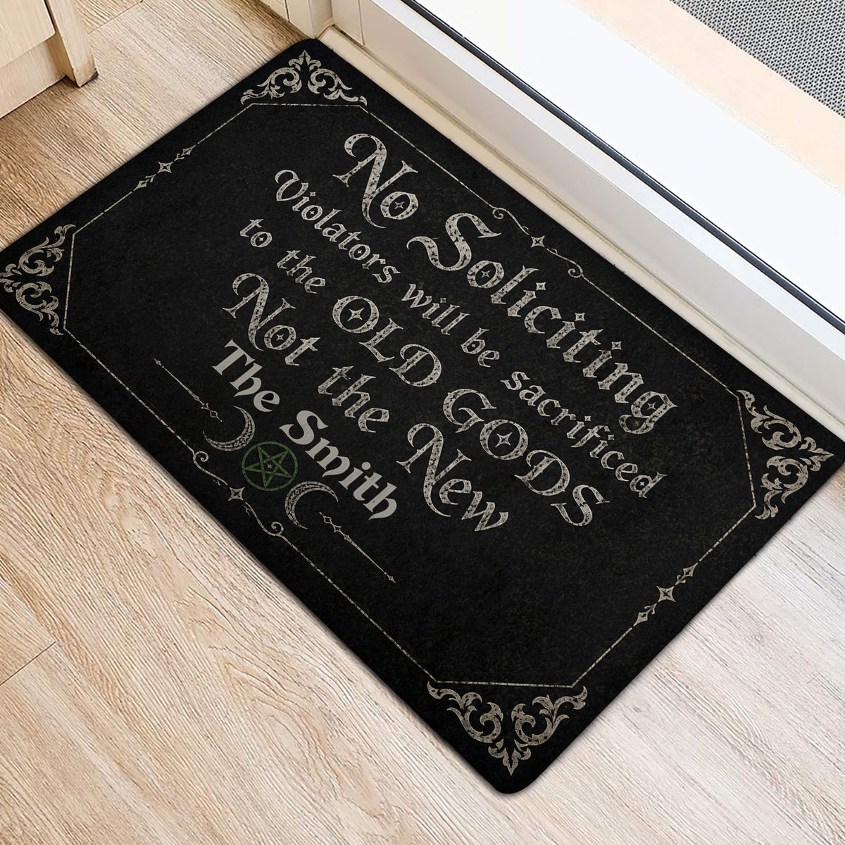 Black witchcraft-themed door mat beside a doorway with crescent moons, pentagram, and ornate details