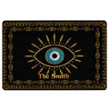 Black evil eye doormat with a blue central eye, gold rays, and decorative geometric border