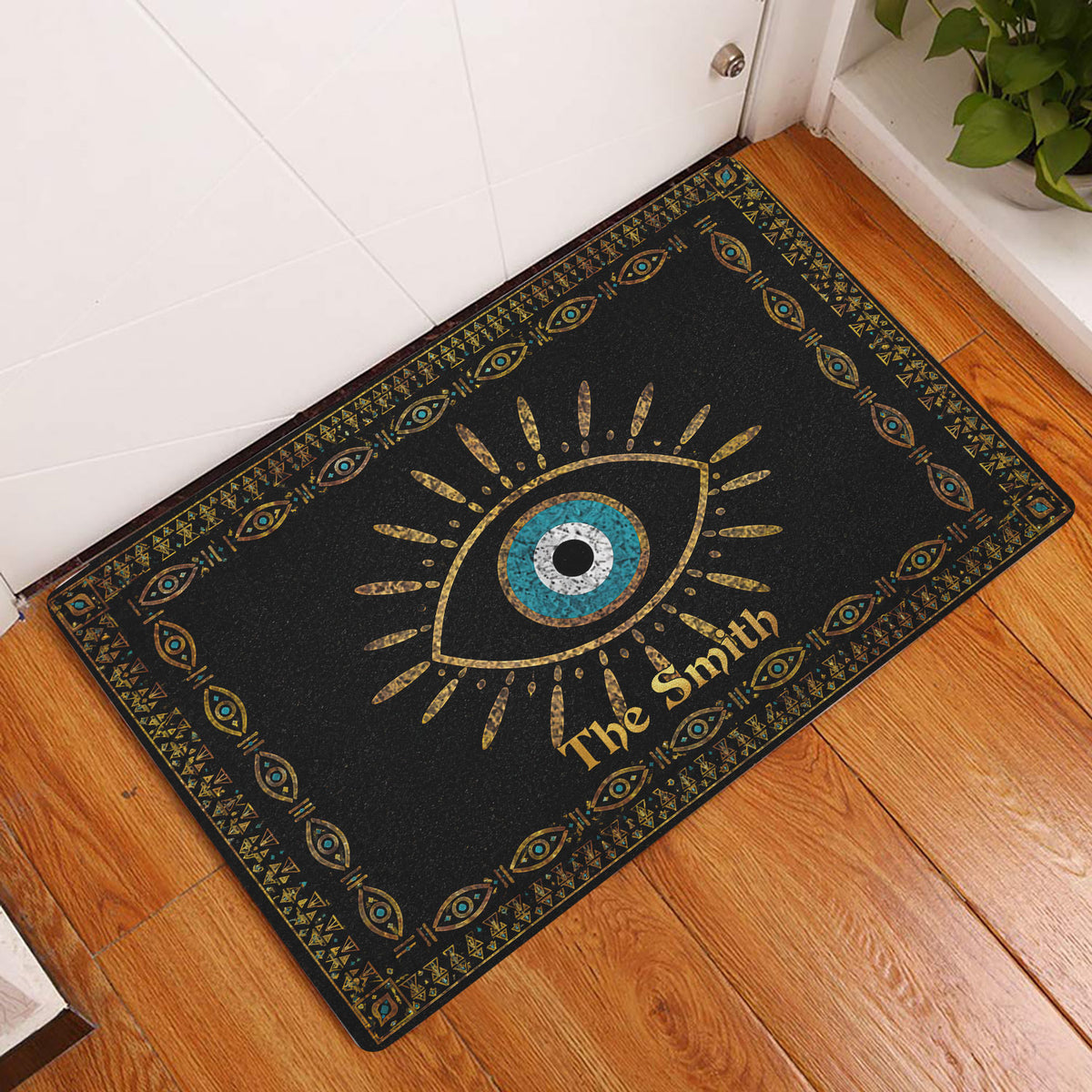 Evil eye entryway doormat displayed beside a white door on warm wood flooring