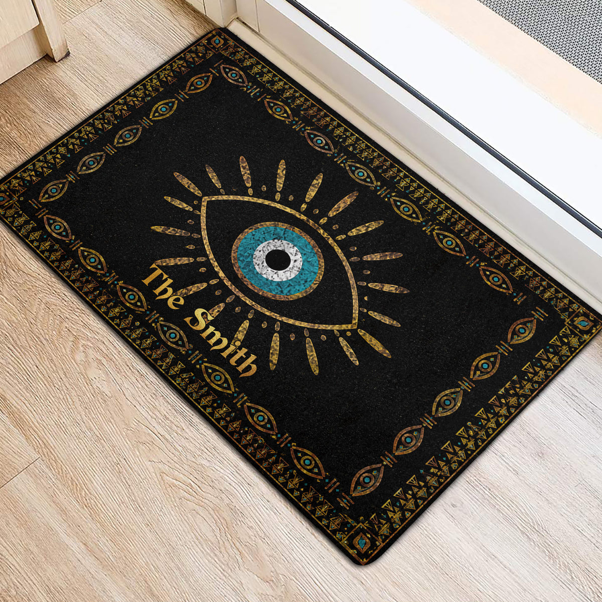 Black and gold evil eye door mat styled at an indoor entrance with geometric border details