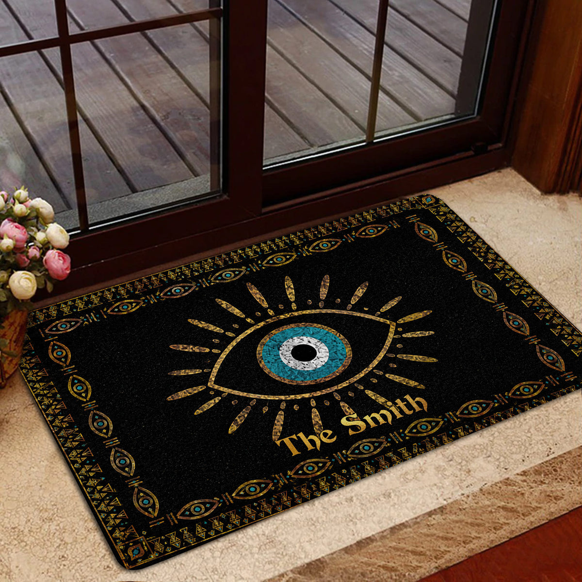 Evil eye rug placed inside a glass doorway with a blue center and ornate gold artwork