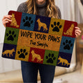 Person holding a colorful German Shepherd doormat featuring paws and dog illustrations