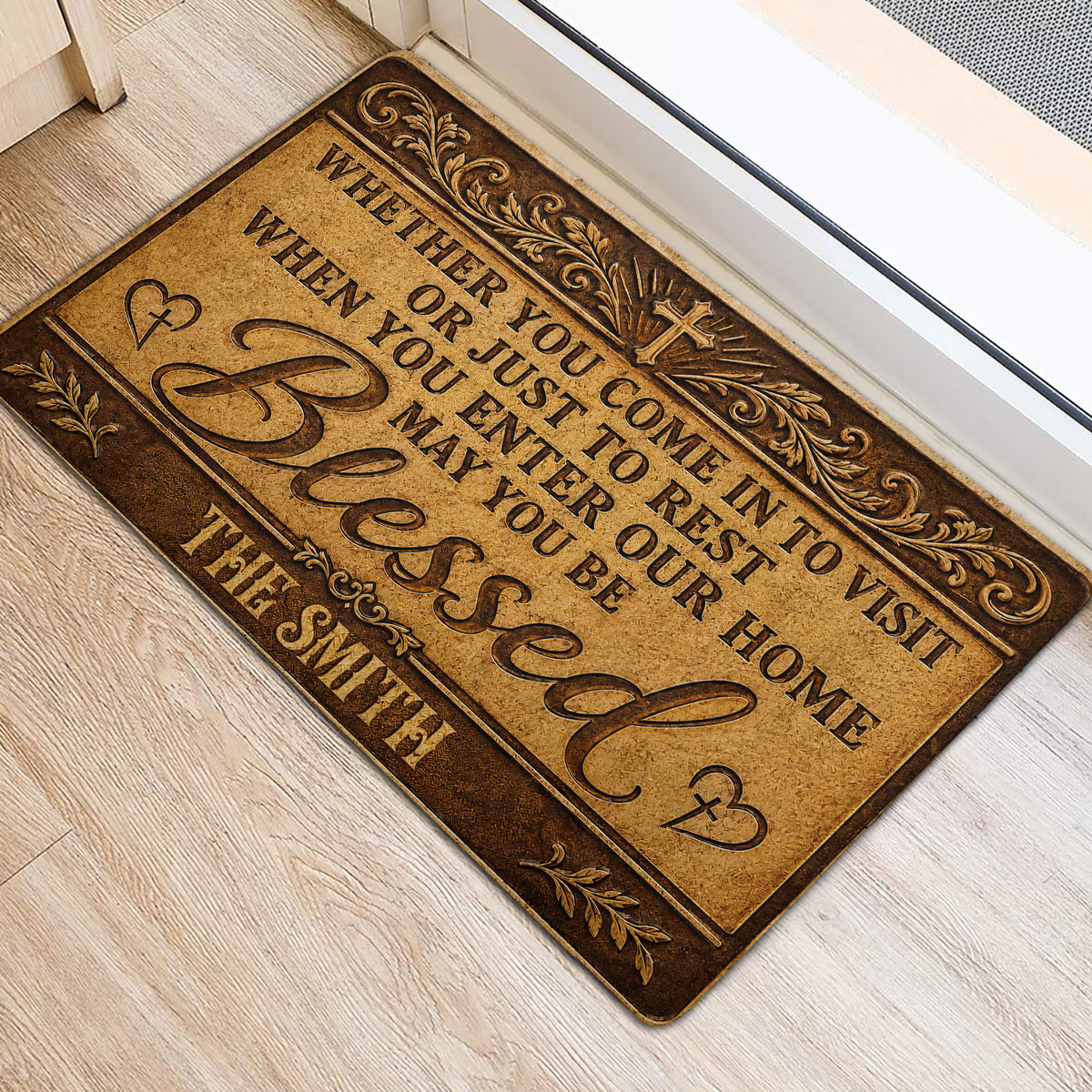 Angled view of an ornate Christian welcome doormat placed beside a light-colored doorway
