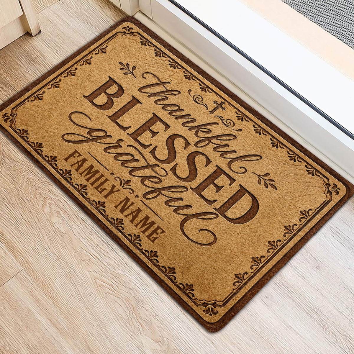 Christian front door mat on light wood flooring featuring blessed and grateful wording with decorative flourishes