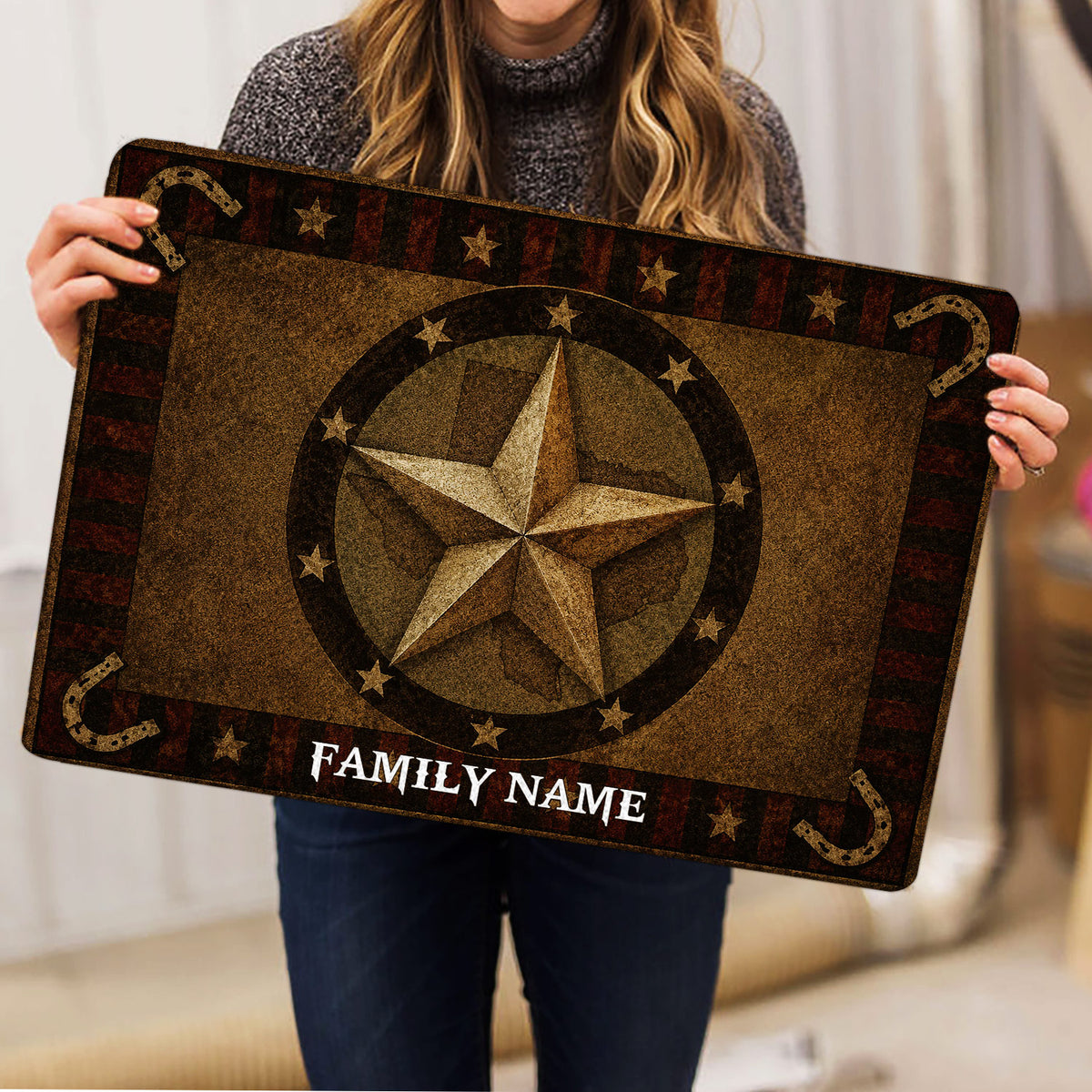 Person holding a rustic Texas western doormat featuring a central star and horseshoe design