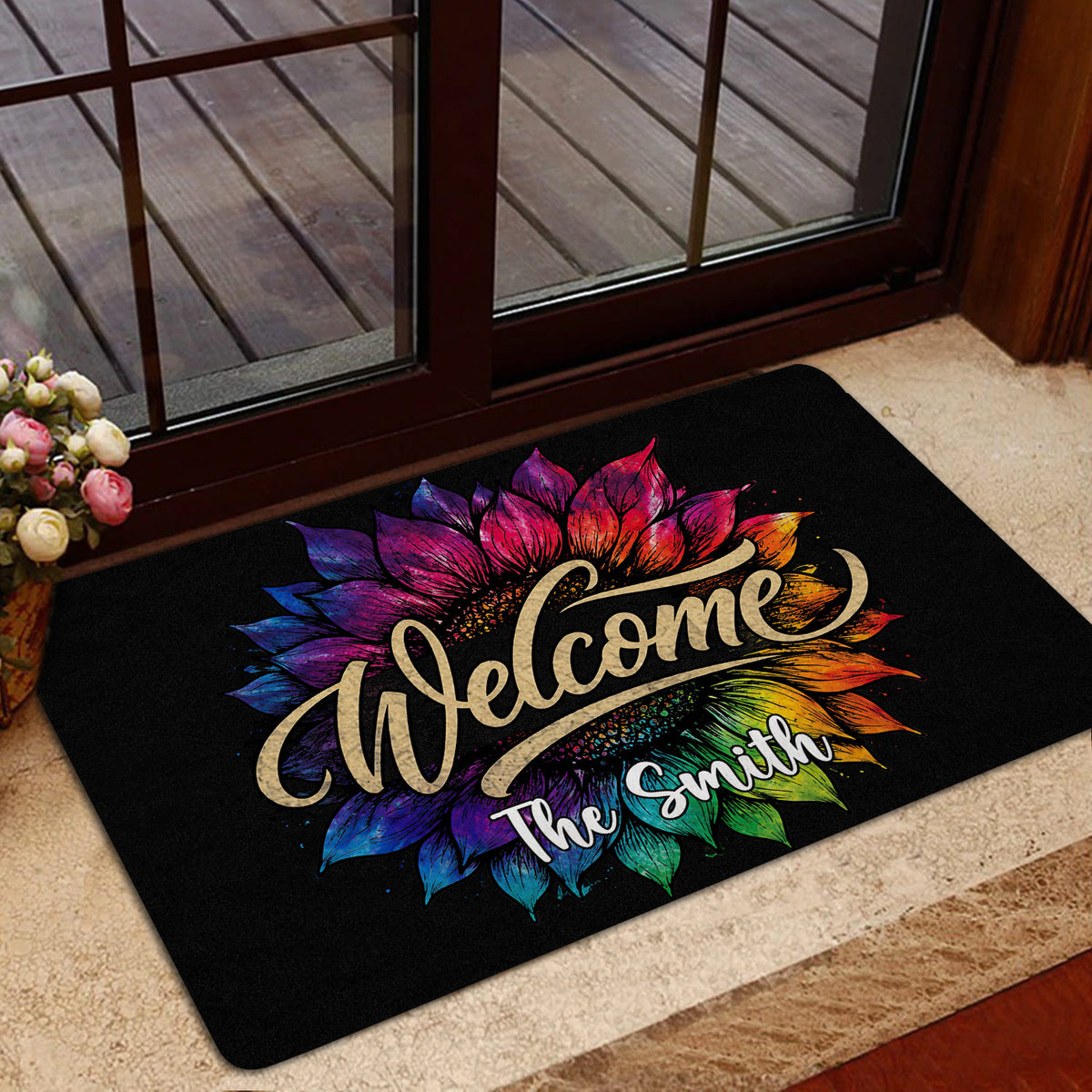 Rainbow sunflower welcome doormat placed inside a glass entrance door on a beige floor