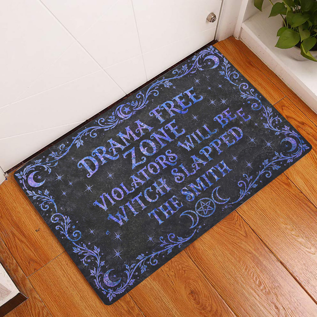 Wicca doormat displayed in an entryway with blue moon, star, and botanical artwork on a black background
