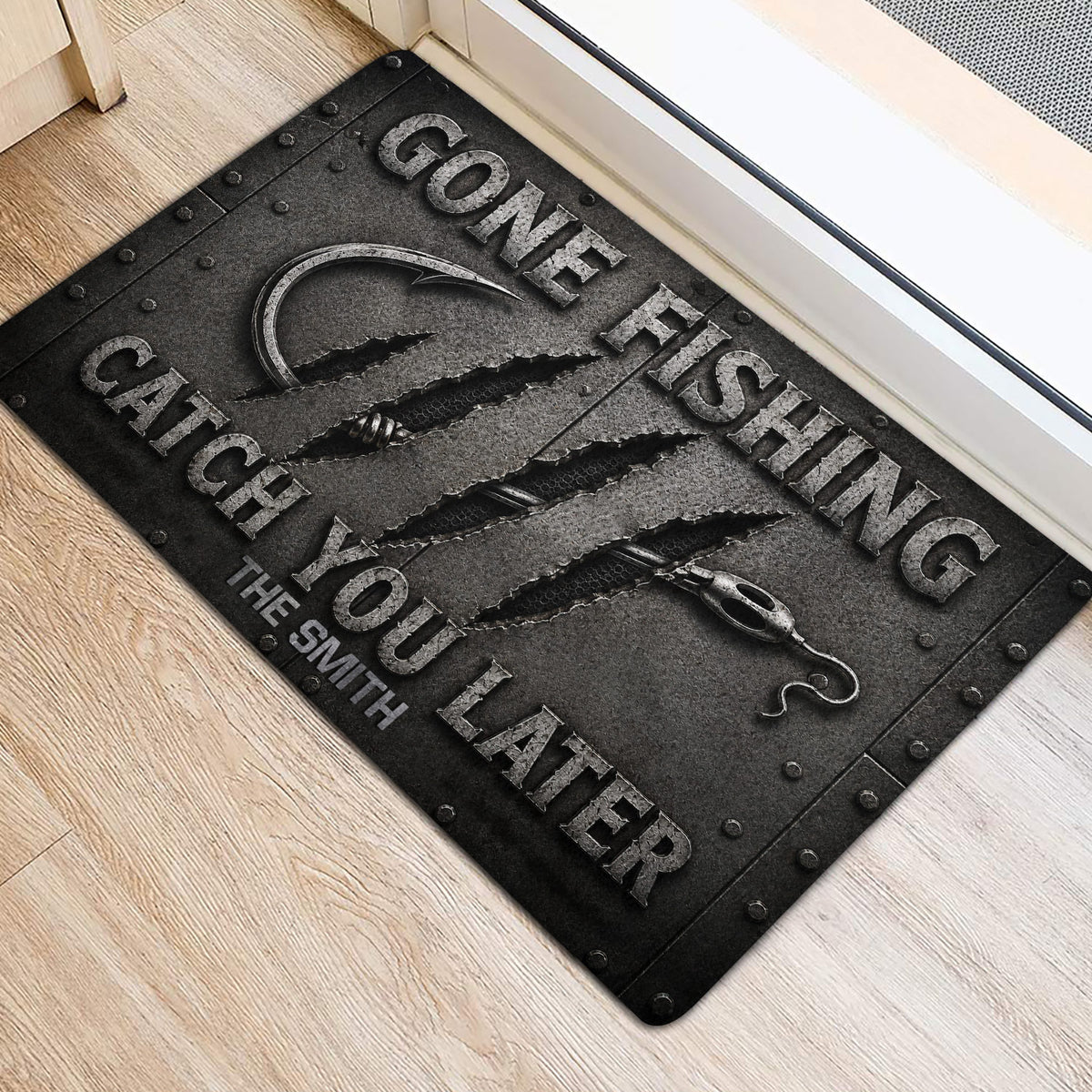 Fishing hook and rugged lettering featured on a doormat positioned near an interior doorway