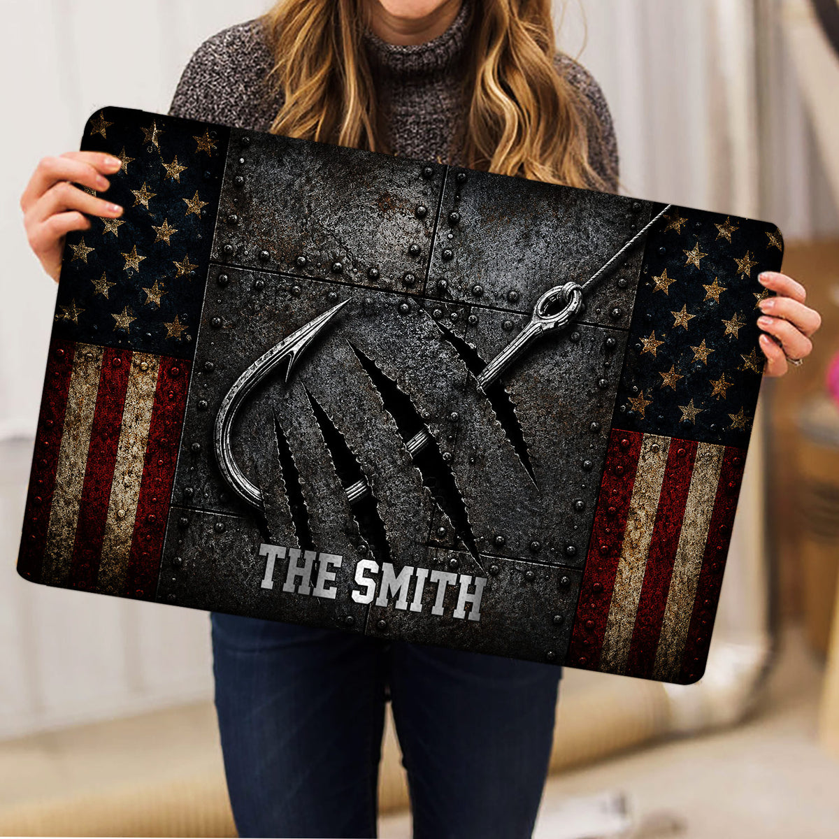 Fishing doormat held indoors, showing crossed hooks, rugged texture, stars, and red, white, and blue stripes