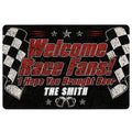 Black racing doormat with red lettering, checkered flags, stars, beer mugs, and a bold race fan theme