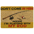 Fishing doormat with a rod, reel, bobber and lure in warm yellow, tan, black and red tones