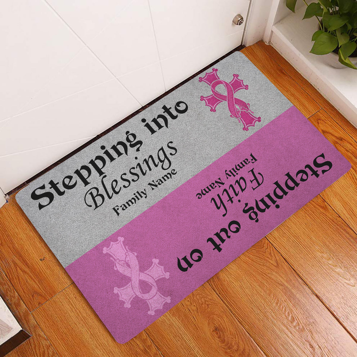 Breast cancer awareness entryway doormat displayed beside a white door on a wood floor