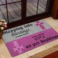 Breast cancer awareness doormat displayed near a glass entry door with pink ribbon artwork