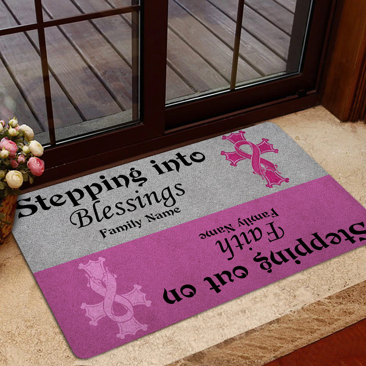 Breast cancer awareness doormat displayed near a glass entry door with pink ribbon artwork