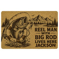 Fishing doormat featuring a leaping fish, fishing rod, mountain lake scene, and bold angler artwork