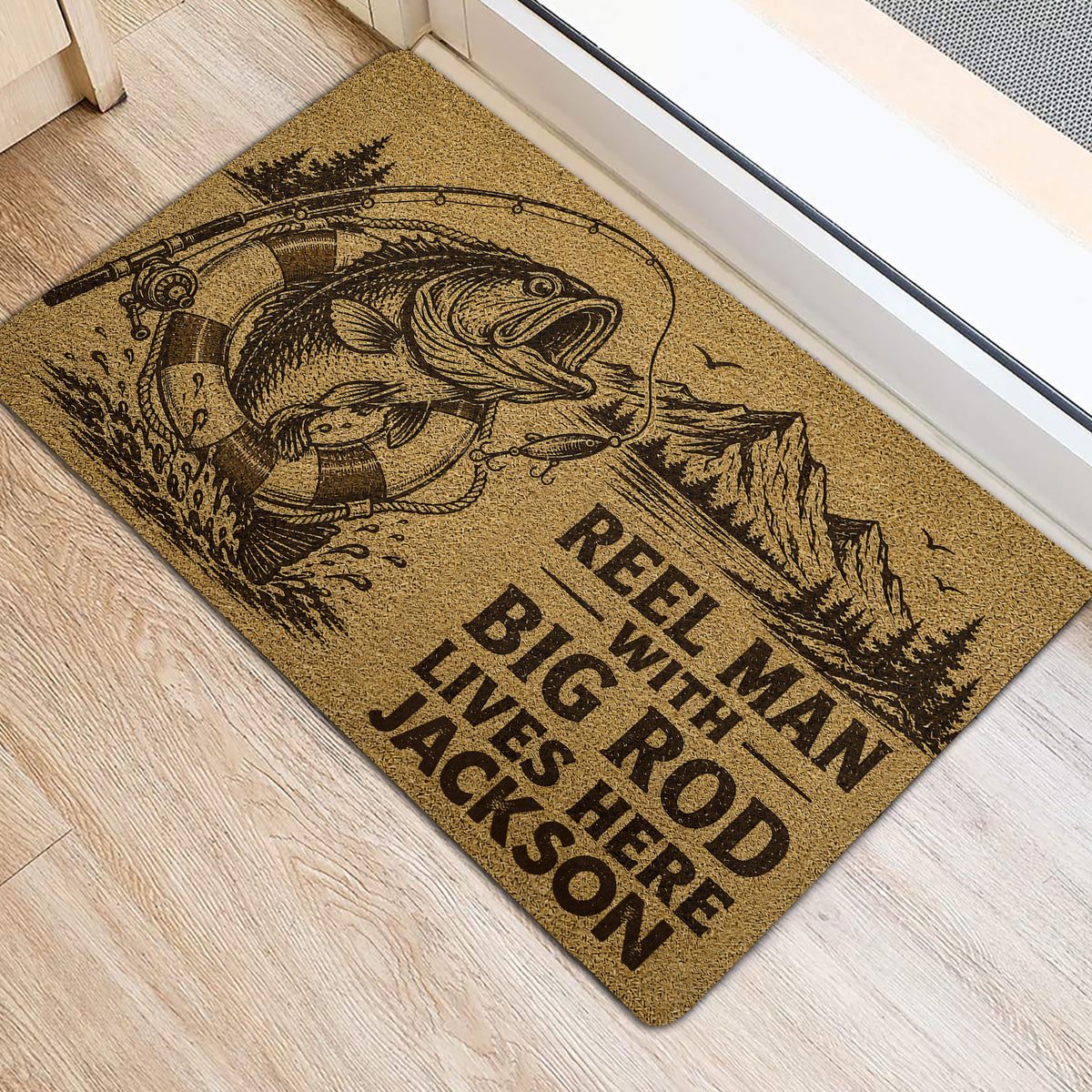 Fishing-themed door mat beside a doorway showing a large fish, fishing rod, lure, and mountain scene
