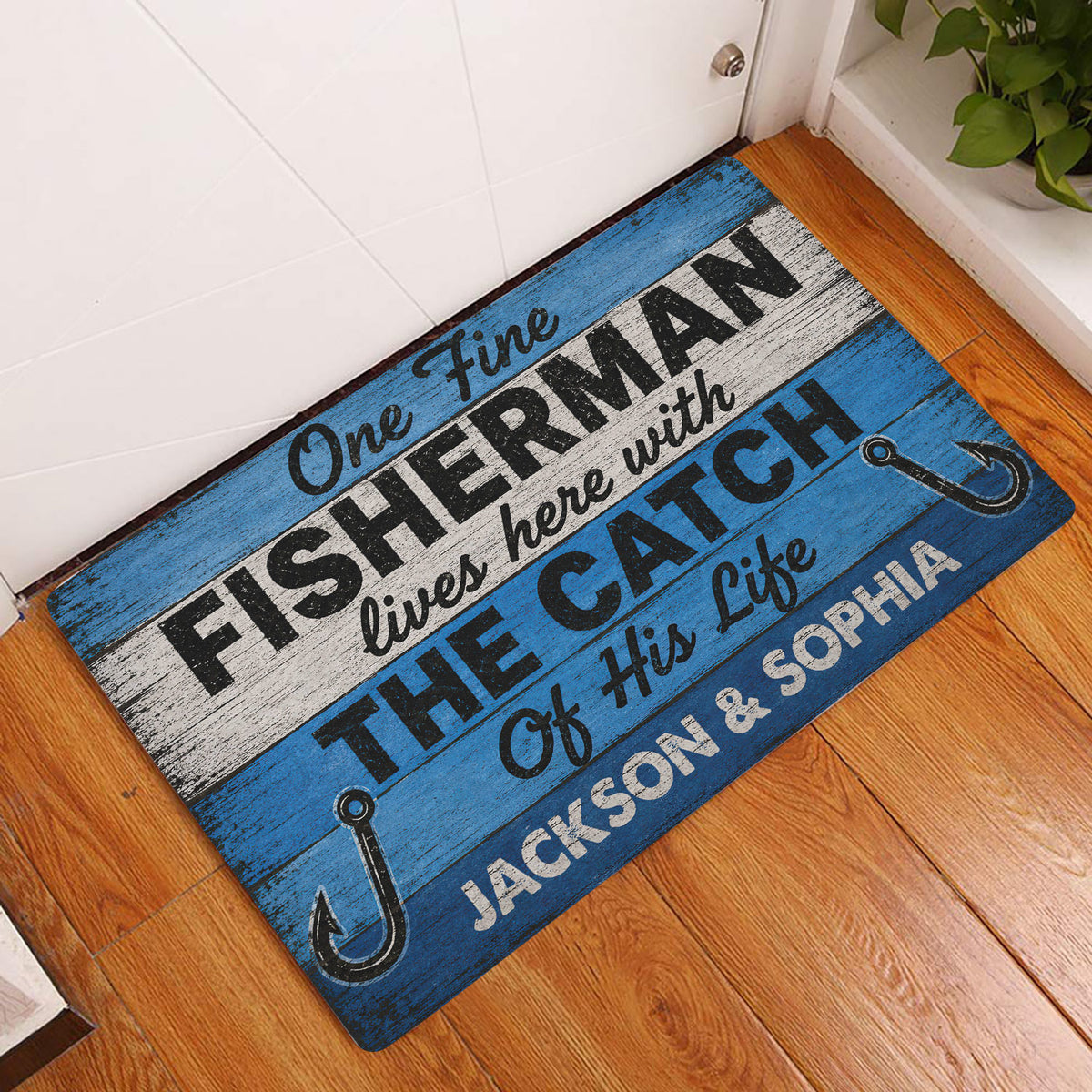 Fishing-themed doormat styled in a home entryway on a warm wood floor