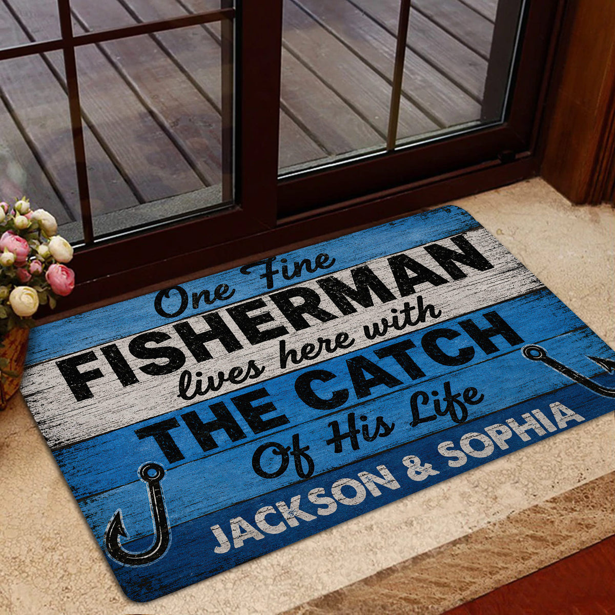 Fishing doormat displayed at a home entrance with glass doors and a welcome setting