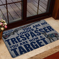 Hunting doormat with rifle and deer design styled beside a glass doorway and indoor entryway