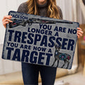 Person holding a hunting doormat featuring a rifle, deer illustration, and bold distressed lettering
