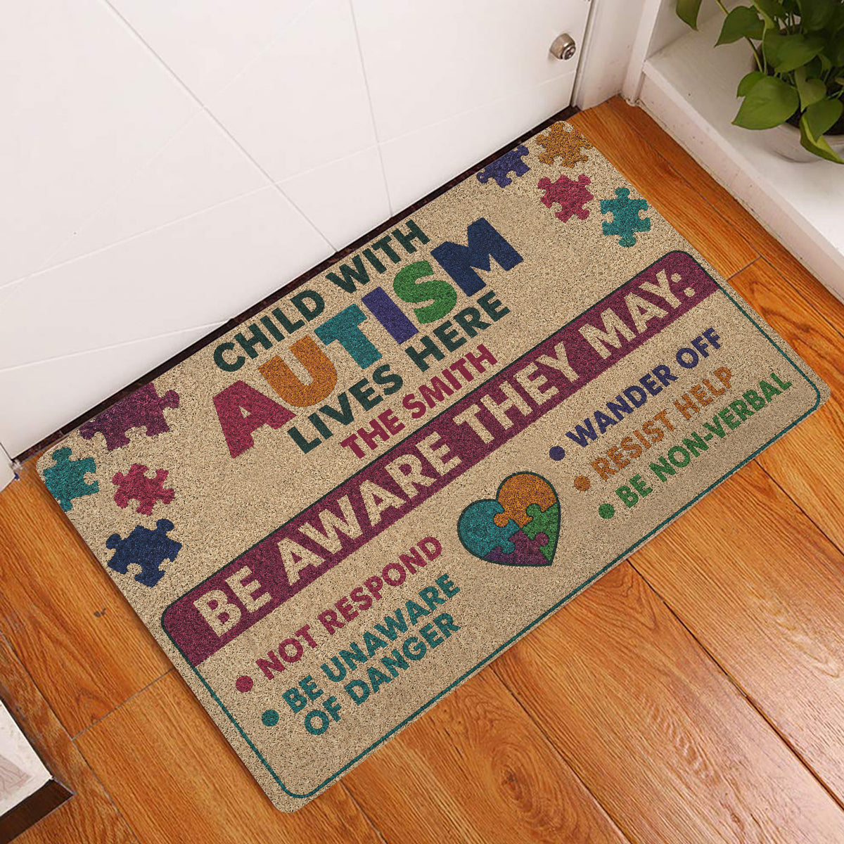 Autism awareness doormat displayed at a front door on hardwood flooring with colorful puzzle-piece artwork